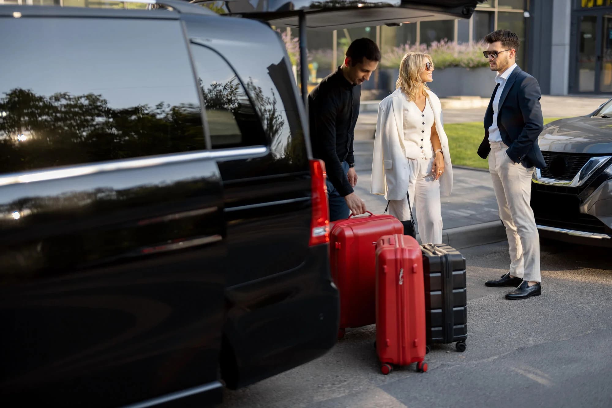 Hotel guests and luggage being loaded curbside for a transfer